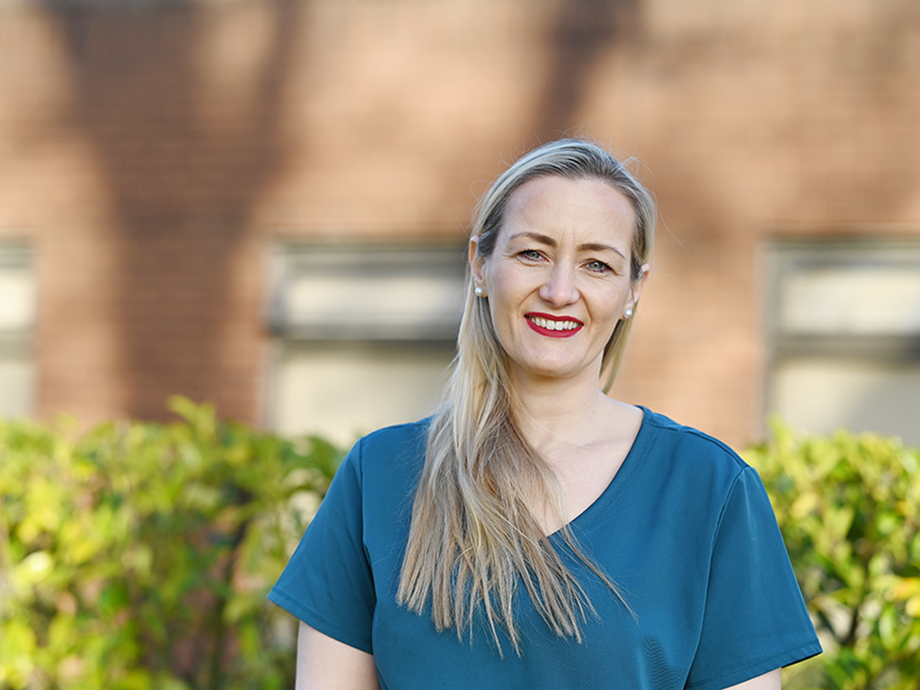 Nurse in uniform outside Beaumont Hosptial smiling at camera